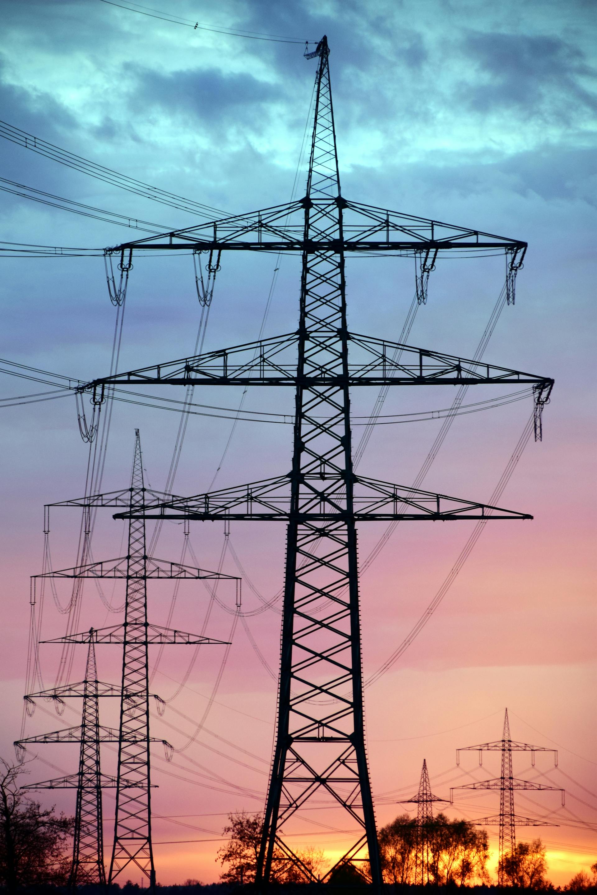 High-voltage electricity transmission tower against blue sky